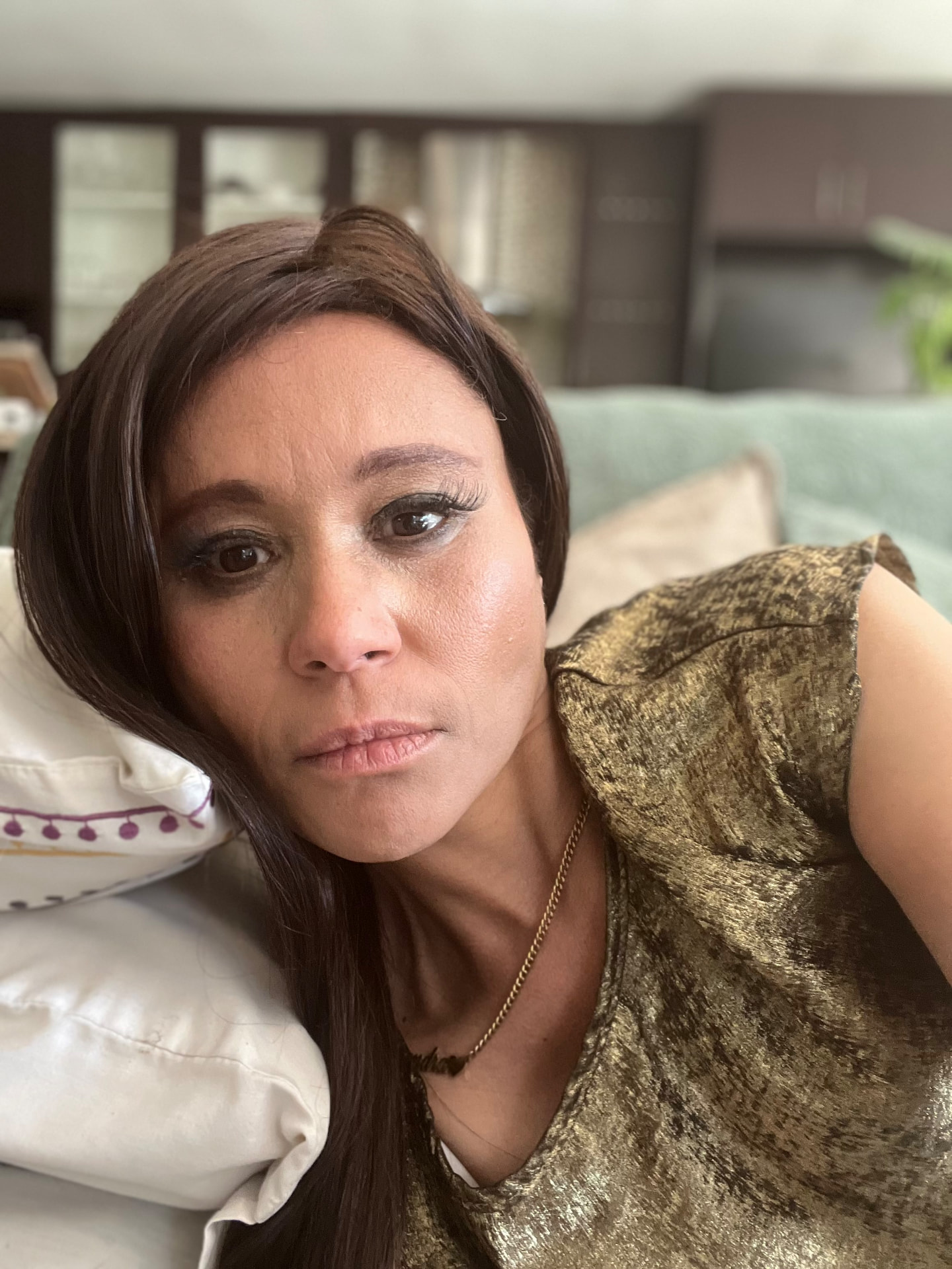 Close portrait of Cass in a gold top with softly smoked eye makeup