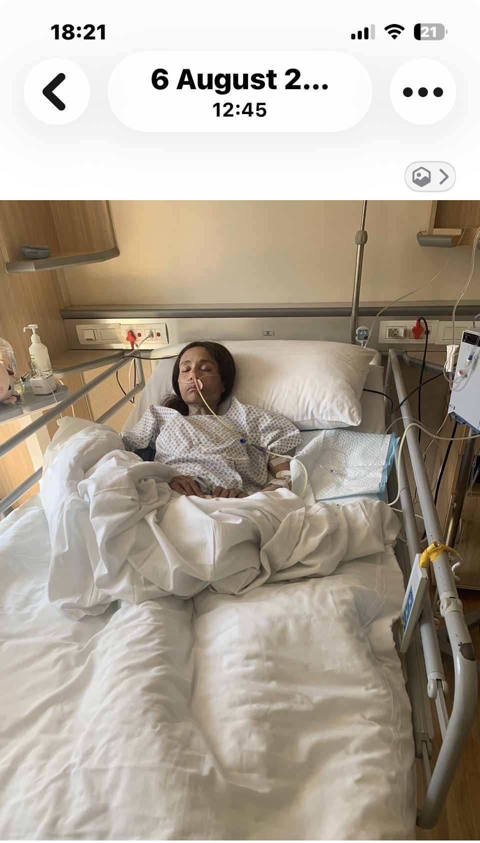 Cass asleep in a hospital bed with a nasogastric feeding tube taped to her cheek, threaded through her nose