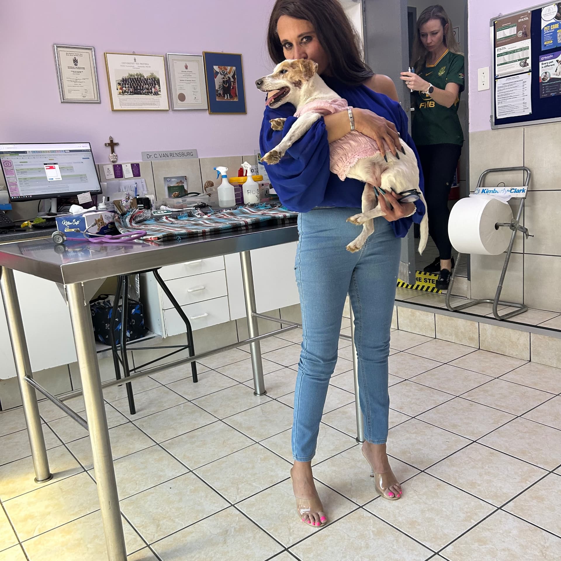 Cass holding Sarah Jessica while Dr Caitlyn prepares the injection in the background