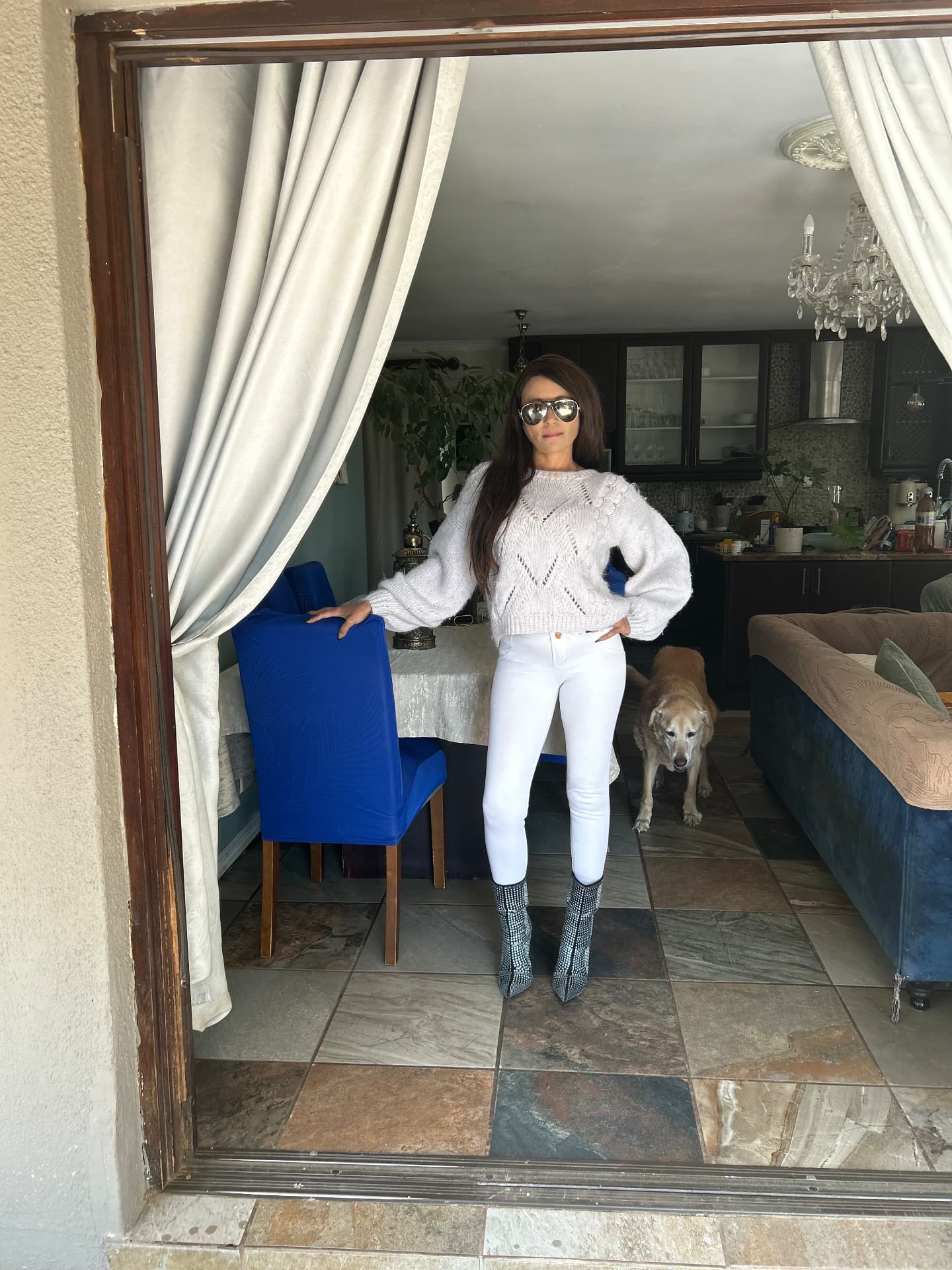 Cass in a hand-knitted cream jersey, white jeans, embellished boots and Versace aviators