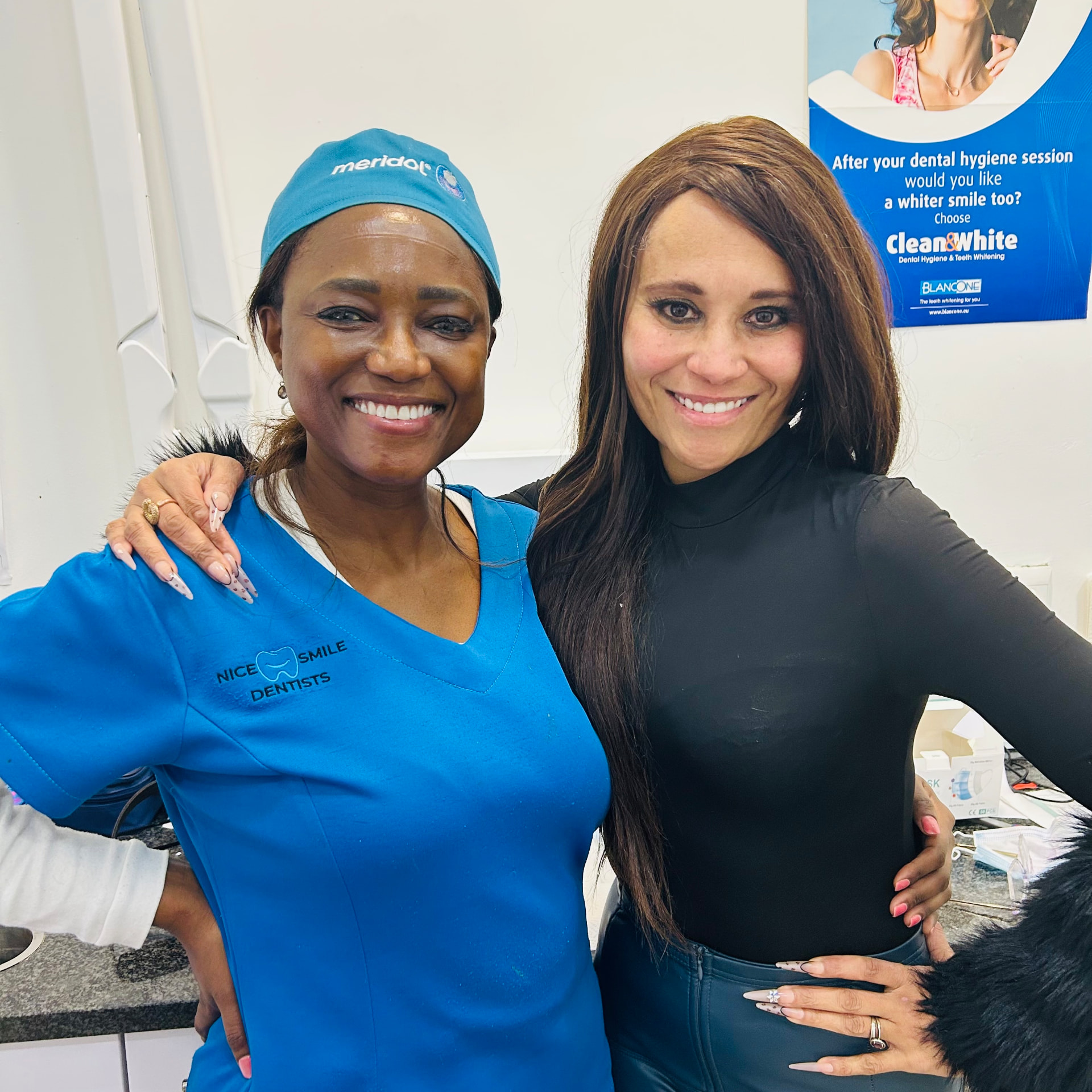 Cass and her dentist, arms around each other, smiling closely at the camera