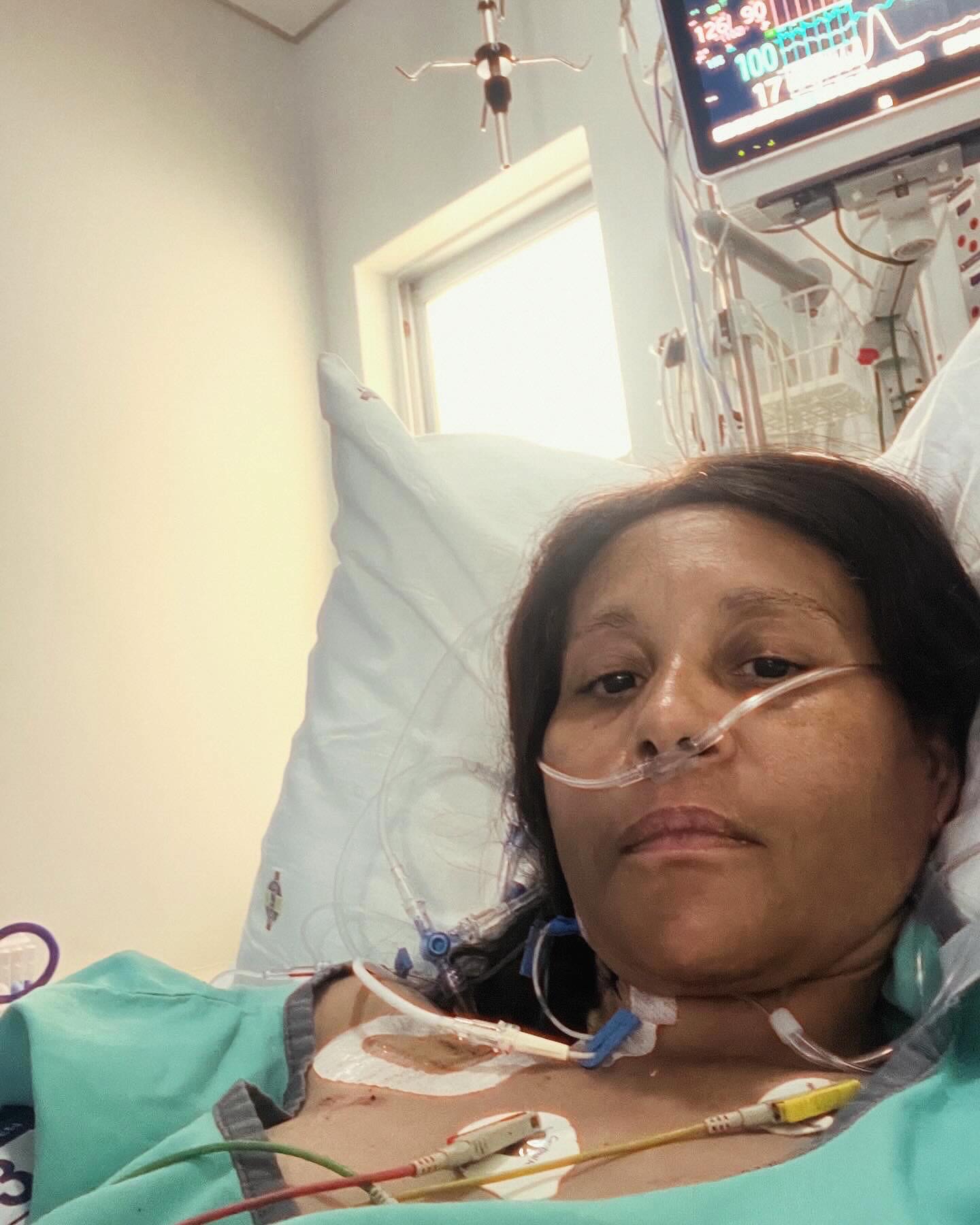 Cass in a hospital bed with nasal cannula, central line and ECG leads — taken during her hospitalisation in 2023/2024