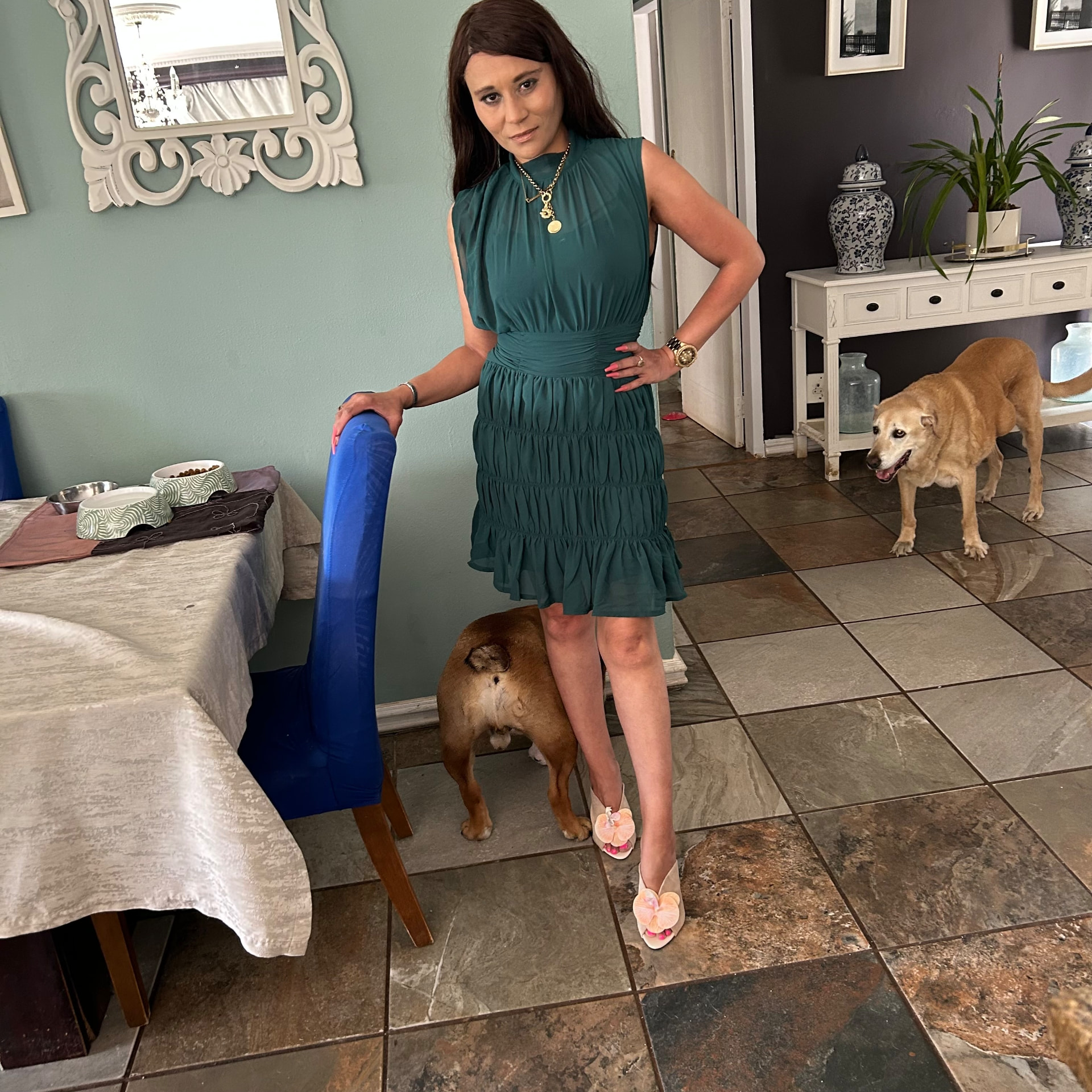 Cass posing tall in the emerald green ruched dress with a gold necklace, like a shop-window mannequin
