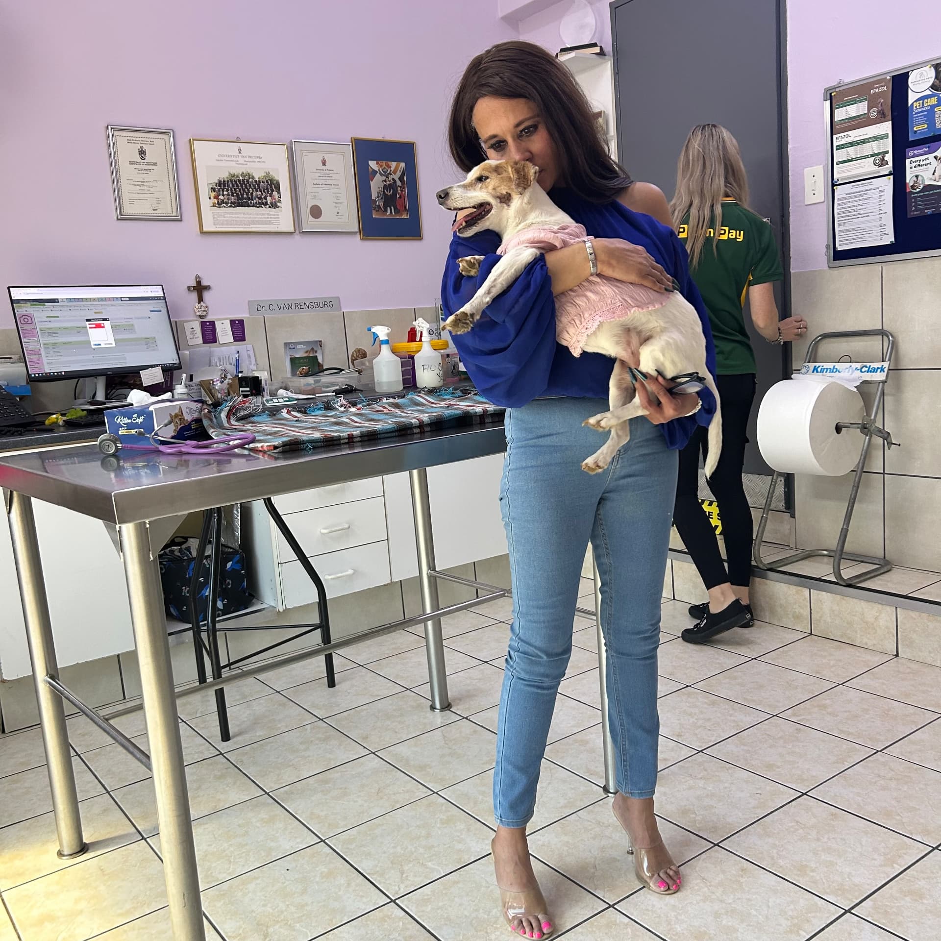 Cass clutching Sarah Jessica tightly at the vet, eyes full of tears