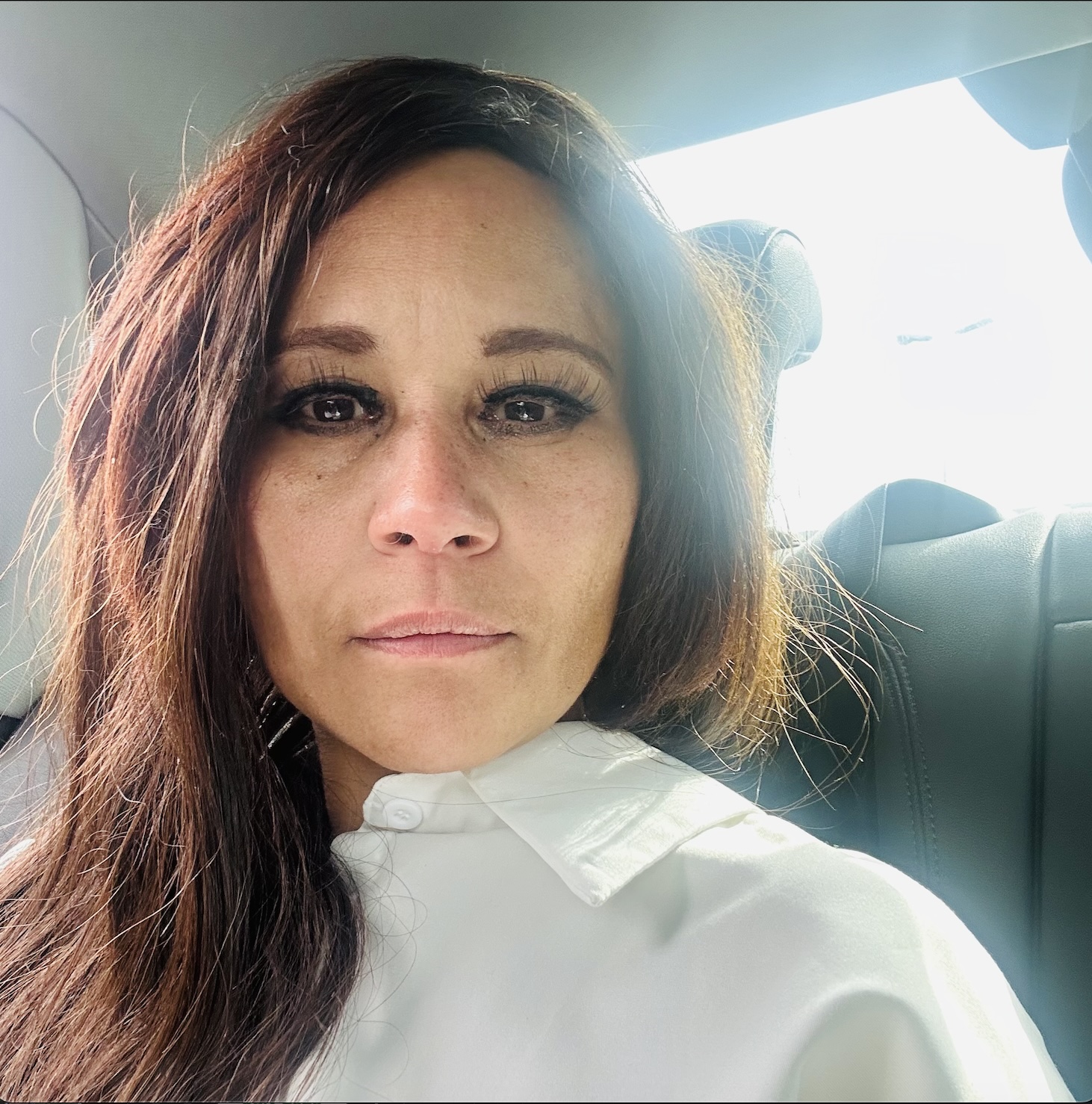 Cass with a fresh face — no foundation, just lashes, eyeliner and brushed brows — soft daylight, white collared shirt