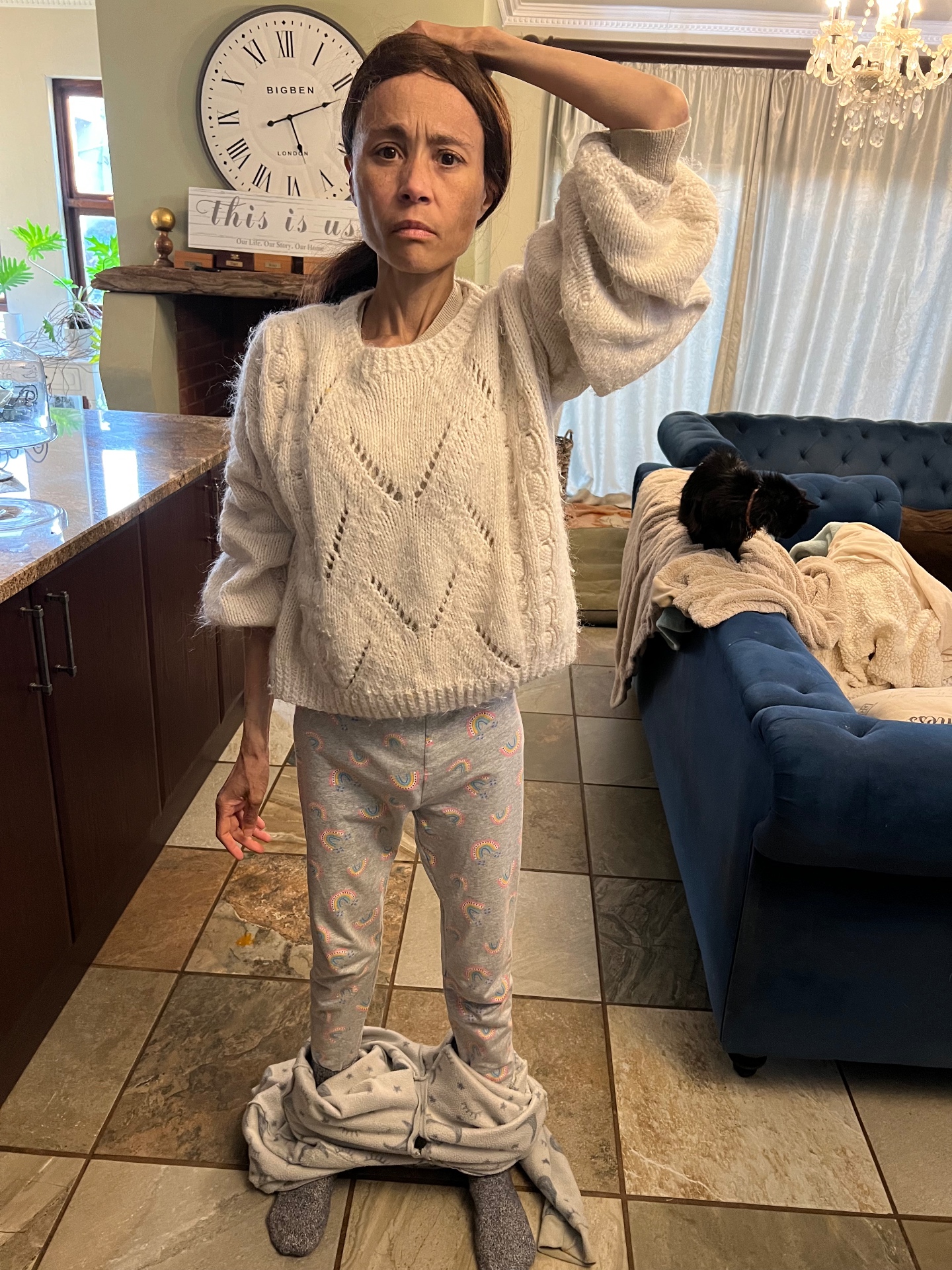Cass standing in her kitchen in 2023, visibly underweight, sweatpants pooled at her ankles — taken shortly before her hospitalisation