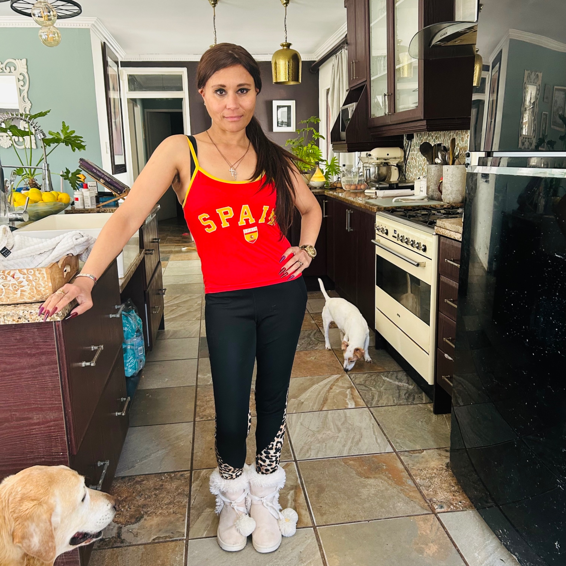 Cass posing with hand on hip in Spain vest and leopard-panel leggings, Jack Russell trotting past